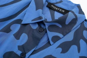 Macro detail of royal blue abstract print shirt collar with neat button stitching
