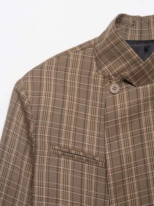 Détail d'un blazer à carreaux marron vintage avec col montant et bouton à boutonnage simple