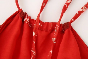 Détail du haut dos nu rouge à imprimé floral blanc montrant les bretelles et le tissu