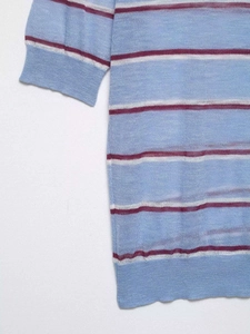 Detailed view of the fine striped knit texture and ribbed cuff on a blue striped top