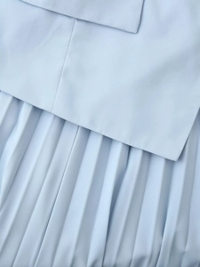 Vue macro du tissu plissé bleu clair montrant la texture fine et le travail artisanal