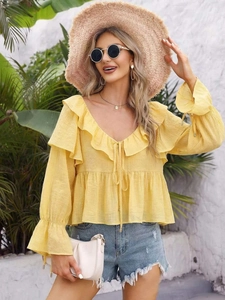 Detail of yellow off-shoulder chiffon blouse with ruffled V-neck and flared elastic sleeves