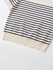 Detail of black and white striped knit top showing the ribbed hem and fine fabric texture