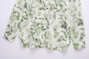 Détail d'une chemise à manches longues avec imprimé floral vert et poche frontale