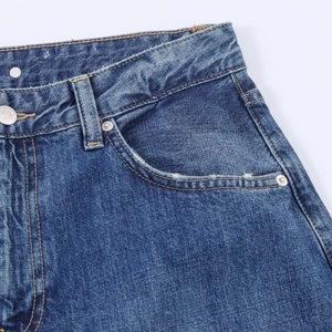 Detail view of dark blue denim jeans waist with metal button and belt loops