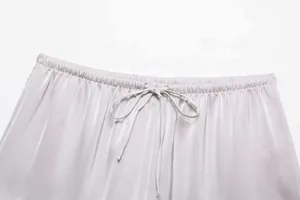 Detail of elastic waist with drawstring on shiny lavender satin shorts fabric