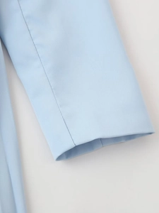 Gros plan de la manche bleu ciel montrant le tissu tissé de qualité et les détails de couture