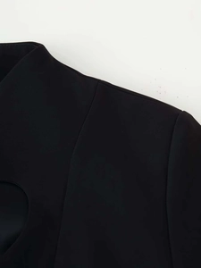 Detailed close-up of a black blazer with unique heart cutout and structured shoulder design