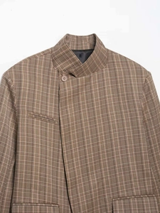 Détail d'un blazer vintage à carreaux avec col mandarin et fermeture asymétrique