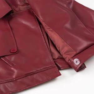 Detailansicht der Nähte und farblich passenden Knöpfe einer burgunderroten Lederjacke