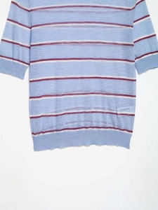 Close-up of light blue striped knit top showing ribbed hem and fine fabric texture