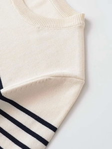 Detail of the crew neck and ribbed knit texture on a navy blue striped shirt