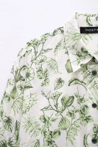 Détail rapproché de l'imprimé tropical sur chemise blanche en coton-lin et boutons noirs