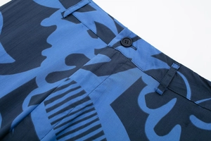Detailed macro view of high-quality resin button and waist stitching on printed trousers
