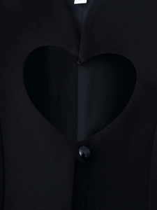 Macro detail of black blazer featuring a heart-shaped cutout and a single polished button