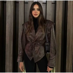 Détail d'une veste en cuir marron foncé vintage avec larges épaules et ceinture à la taille