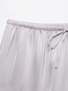 Detailed macro view of gray satin shorts featuring elastic waistband and adjustable drawstring