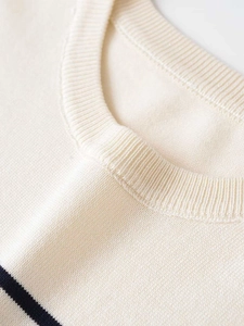 Detail of soft cream knit neckline with ribbed edging and navy blue stripe