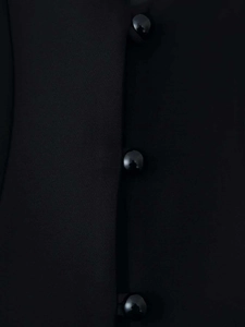 Close-up of glossy black dome buttons and textured fabric on a women's blazer jacket
