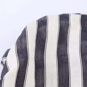 Detailed close-up of vertical black and white striped breathable fabric on sleeveless dress