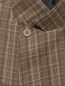 Détail macro du tissu à carreaux vintage du blazer avec bouton marron mat et coutures fines
