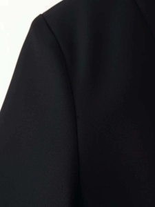 Macro detail of high-quality black twill fabric and shoulder stitching on casual blazer