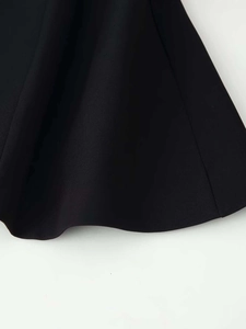 Detailed view of black blazer hem showing premium fabric texture and clean stitching