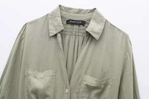 Detail view of sage green linen blend shirt dress with pocket and resin button