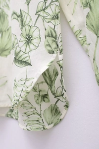 Détail de la fente latérale et de l'ourlet arrondi sur la chemise à fleurs