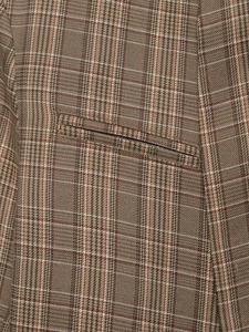 Vue macro du tissu à carreaux marron d'un blazer avec poche passepoilée et laine