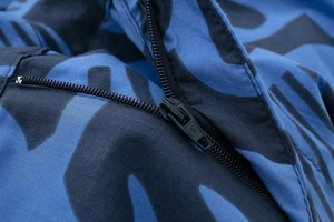 Macro detail of high-quality zipper on printed blue and black fabric with twill texture