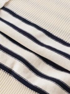 Close-up of the premium ribbed knit fabric featuring navy blue stripes on cream material