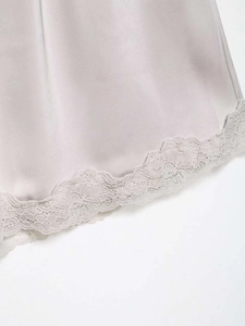 Detail of grey satin fabric with delicate lace trim showcasing smooth silk texture