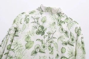 Détail de l'imprimé floral tropical sur chemise blanche à manches longues avec col classique