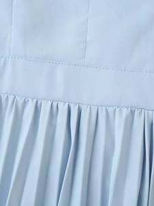 Détail de la couture à la taille et de la texture plissée de la robe bleu clair