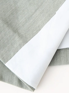 Detail of the high-quality grey-green and white textured linen fabric on the suit set