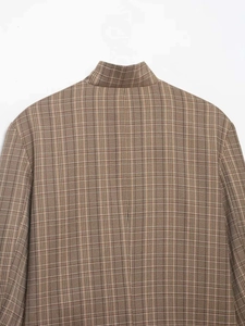 Détail du col d'un blazer marron à carreaux et texture du tissu en laine de qualité