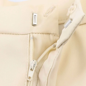 Vue avant d'un short en satin beige avec fermeture par crochet en métal et braguette