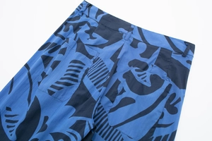 Close-up of waistband and back pocket detail on blue and black print trousers