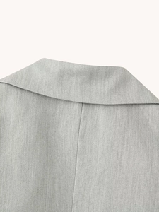 Close-up of light gray woven suit jacket collar showing fine fabric texture and neat stitching