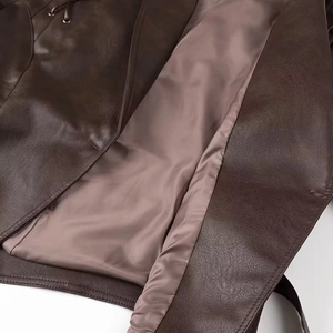 Gros plan détaillé du blouson en cuir marron foncé avec doublure en satin mauve
