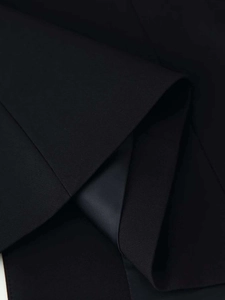 Detail of premium black blazer fabric with smooth satin lining and fine stitching