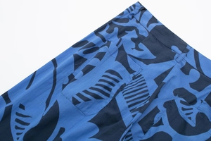 Detail of blue floral print pants with belt loops and stitching on breathable fabric