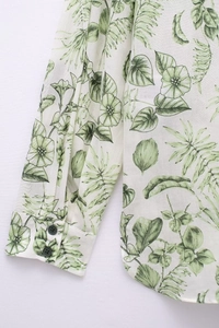 Détail de l'imprimé floral vert sur manche de chemise blanche à double boutons