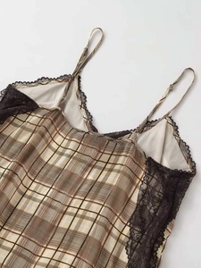 Détail d'un caraco en satin à carreaux avec bordure en dentelle noire et fines bretelles