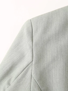 Detailed macro view of high-quality light grey fabric texture on women suit shoulder seam