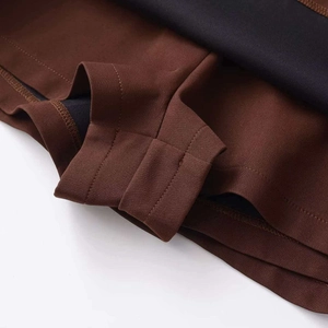 Detailed macro view of dark brown high-waisted skirt showing stitching and black lining