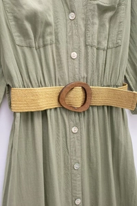 Detail of green linen blend shirt dress with pearl buttons and yellow woven belt with wooden ring