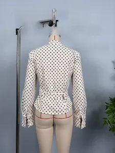 Detailed back view of a white polka dot long sleeve shirt with a matching waist belt