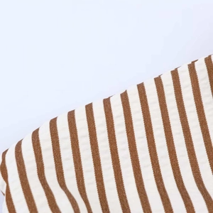 Macro shot of breathable brown and white seersucker striped fabric texture and detail